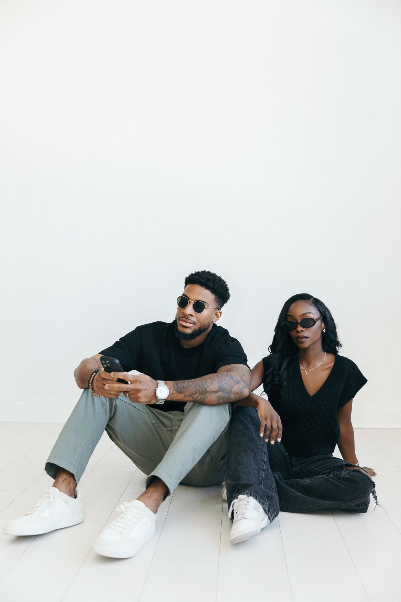 Avrielle and Elijah Muse in sunglasses, seated on the studio floor